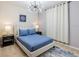 Bright bedroom featuring a modern bed frame, stylish lighting, and fresh decor at 3926 Lana Ave, Davenport, FL 33897