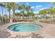 Community hot tub with lush landscaping and community clubhouse in the background at 4119 Bella Isle Cir, Kissimmee, FL 34746