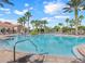 Beautiful community pool with tropical landscaping, lounge chairs, and a bright blue sky at 4119 Bella Isle Cir, Kissimmee, FL 34746