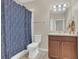 Bathroom showcasing a blue shower curtain, vanity with storage, and neutral wall color at 486 Windmill Palm Cir, Altamonte Springs, FL 32701