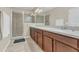 Bathroom featuring a double sink vanity, modern lighting, and tiled shower with glass door at 486 Windmill Palm Cir, Altamonte Springs, FL 32701