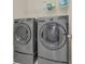 Laundry room with modern, front-load, gray washer and dryer at 486 Windmill Palm Cir, Altamonte Springs, FL 32701