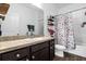 Functional bathroom featuring a vanity with a sink, mirror, and a shower with floral curtain at 4860 Osprey Way, Winter Haven, FL 33881