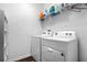 Bright laundry room with white washer and dryer, shelving, and dark wood baseboards at 4860 Osprey Way, Winter Haven, FL 33881