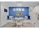 Bright dining area showcases a blue accent wall, cozy seating nook, and elegant chandelier lighting at 5405 Hansel Ave # G9, Orlando, FL 32809