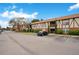 Wide view of condo exterior displays Tudor accents, brick facade, landscaping, and parking at 5405 Hansel Ave # G9, Orlando, FL 32809