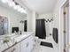 Well-lit bathroom with a combination shower and tub, a granite vanity and a black and white tiled floor at 580 Water St # F, Kissimmee, FL 34747