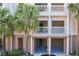 Exterior view showing multiple balconies with white railings and lush tropical landscaping at 580 Water St # F, Kissimmee, FL 34747