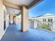 Outdoor hallway with large support beams, white railings, and view of the neighborhood at 580 Water St # F, Kissimmee, FL 34747