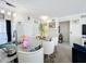 Open concept kitchen island featuring white chairs, granite countertop, pendant lighting and dining into the living room at 580 Water St # F, Kissimmee, FL 34747