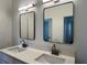 Close-up of bathroom double vanity featuring modern sinks, quartz countertop, and black framed mirrors at 583 Brantley Terrace Way # 303, Altamonte Springs, FL 32714