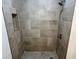 The remodeled walk-in shower features neutral tile, built-in shampoo nook, and a rainfall shower head at 583 Brantley Terrace Way # 303, Altamonte Springs, FL 32714