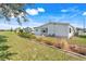 Well-maintained home exterior featuring a green lawn and manicured garden beds at 6302 Bayberry Ne Blvd, Winter Haven, FL 33881