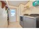 Well-lit laundry room with modern washer and dryer, and storage shelves at 6302 Bayberry Ne Blvd, Winter Haven, FL 33881