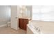 Bright bathroom featuring a tub, single sink vanity, and natural light from a window with privacy blinds at 6825 Dolce St, Orlando, FL 32819