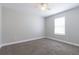 Cozy bedroom with neutral paint, carpet floors, and a bright window at 6825 Dolce St, Orlando, FL 32819