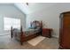 Bedroom with carpet, window, bed, nightstand and dark-stained furniture at 6825 Dolce St, Orlando, FL 32819
