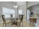 Dining area featuring a glass table, chandelier lighting and neutral colored tile flooring at 6825 Dolce St, Orlando, FL 32819