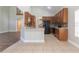 Open kitchen with a breakfast bar, wood cabinets, and a view of the living area and staircase at 6825 Dolce St, Orlando, FL 32819