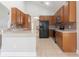 Bright kitchen with wood cabinetry, mosaic backsplash, and black appliances at 6825 Dolce St, Orlando, FL 32819