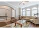 Elegant living room featuring archways, hardwood floors, neutral color palette, and large windows at 6825 Dolce St, Orlando, FL 32819