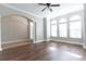 Bright living room featuring hardwood floors, arched doorway, and large windows at 6825 Dolce St, Orlando, FL 32819