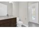 Modern bathroom with a dark wood vanity, white toilet, and a walk-in shower at 8309 Park Cliff Way, Orlando, FL 32836