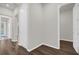 Hallway featuring wood-look flooring, white trim, and doorways leading to various rooms throughout the house at 8309 Park Cliff Way, Orlando, FL 32836