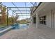 An in-ground pool featuring a screen enclosure, attached spa, and neutral colored pavers at 8309 Park Cliff Way, Orlando, FL 32836