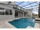 A beautiful in-ground pool with screen enclosure, featuring a spa and neutral-colored pavers at 8309 Park Cliff Way, Orlando, FL 32836