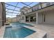 A serene in-ground pool featuring a spa, screen enclosure, and neutral colored pavers at 8309 Park Cliff Way, Orlando, FL 32836