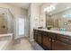 Bathroom with a double vanity, dark wood cabinetry, shower and soaking tub at 8920 Rhodes St, Kissimmee, FL 34747