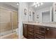 Bathroom featuring a granite countertop, dark wood cabinets, and a glass-enclosed shower with neutral tile at 8920 Rhodes St, Kissimmee, FL 34747