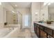 Bright bathroom featuring a large soaking tub, glass enclosed shower and double vanity at 8920 Rhodes St, Kissimmee, FL 34747