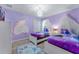 Charming bedroom with themed decor, including twin beds, a castle-shaped light, and purple walls at 8920 Rhodes St, Kissimmee, FL 34747