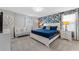 Bright bedroom features a cozy crib and a queen-size bed with vibrant floral wallpaper at 8920 Rhodes St, Kissimmee, FL 34747