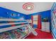 Fun bedroom featuring custom-painted walls, Marvel decor, bunkbeds with a slide, a large window and a red carpet at 8920 Rhodes St, Kissimmee, FL 34747