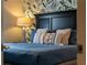 Cozy bedroom featuring a stylish bed with decorative pillows and patterned wallpaper at 8920 Rhodes St, Kissimmee, FL 34747