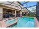 Screened-in pool with hot tub, lounge seating, and secure fencing surrounding the pool area at 8920 Rhodes St, Kissimmee, FL 34747