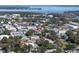 Aerial view of a town with a variety of buildings and commercial areas, surrounded by green trees and waterways at 9157 Harris Hawk Dr, Leesburg, FL 34788