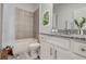 Well-lit bathroom with a granite vanity top, tiled shower, and a clean, contemporary design at 9157 Harris Hawk Dr, Leesburg, FL 34788