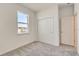 A bright bedroom featuring neutral carpeting and a closet with sliding doors at 9157 Harris Hawk Dr, Leesburg, FL 34788