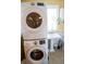 Bathroom with modern stacked washer dryer and a white pedestal sink at 9919 Hickory Hollow Rd, Leesburg, FL 34788