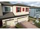 Two-story home featuring a brick driveway, two-car garage, red shutters, and stone veneer accents at 2523 Econ Landing Blvd, Orlando, FL 32825