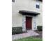 Inviting red front door with stone trim surround and a brick walkway at 2523 Econ Landing Blvd, Orlando, FL 32825