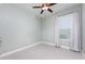 Neutral bedroom with a ceiling fan and a large window at 113 Azure Mist Way, Daytona Beach, FL 32124