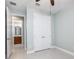 Empty bedroom boasts tile floors, a ceiling fan, and a walk-in closet with a glimpse of the ensuite bathroom at 113 Azure Mist Way, Daytona Beach, FL 32124