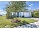 Beautifully landscaped front exterior featuring a well-manicured lawn, tasteful plantings, and a two-car garage at 113 Azure Mist Way, Daytona Beach, FL 32124