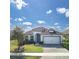 Beautifully landscaped front exterior featuring a well-manicured lawn, tasteful plantings, and a two-car garage at 113 Azure Mist Way, Daytona Beach, FL 32124