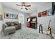 A fun game room features a ceiling fan, gray sofa, and vintage arcade games at 113 Azure Mist Way, Daytona Beach, FL 32124
